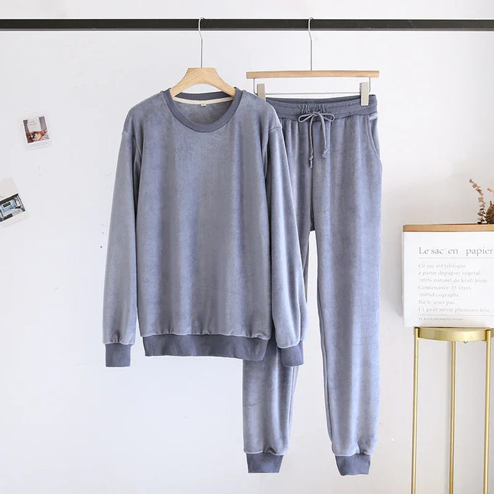 Soft gray fleece sweatpants and long-sleeve sweatshirt loungewear set hanging on wood hangers