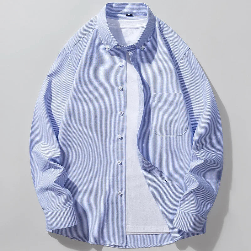 Blue and white thin striped button-up shirt layered over a plain white t-shirt on gray background