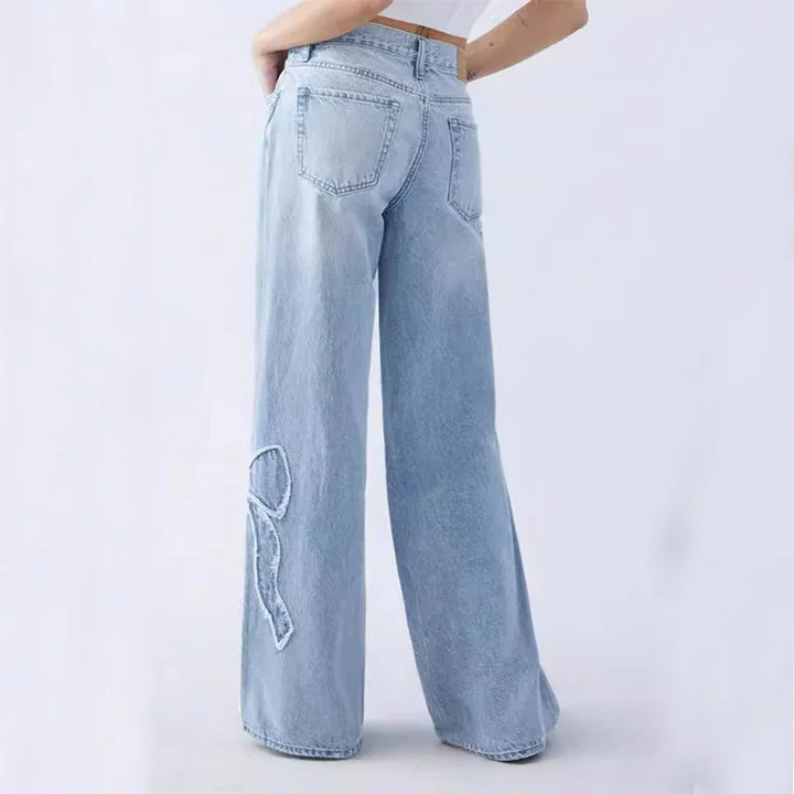 Back view of light blue wide-leg jeans with embroidered R detail on left leg