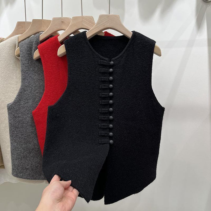 Black sleeveless wool vest with fabric-covered buttons on wooden hanger, with gray, red, and beige vests behind