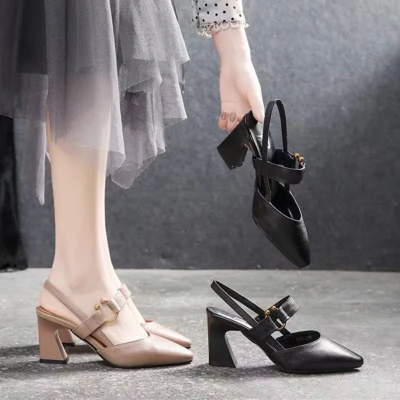 Woman wearing beige block heel slingback shoes holding a pair of black block heel slingback shoes