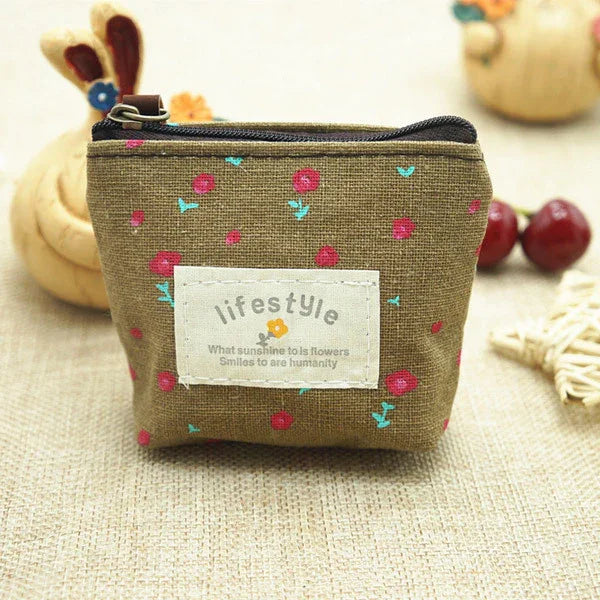 Small brown fabric coin purse with red flower print and zipper, labeled lifestyle with a quote
