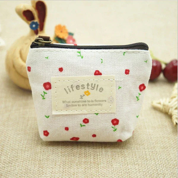 Small beige fabric coin purse with red flower print and 'lifestyle' label, zipper closure