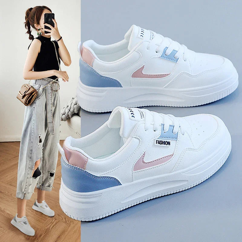 white casual sneakers with light blue and pink accents, worn by woman in black sleeveless top and distressed jeans