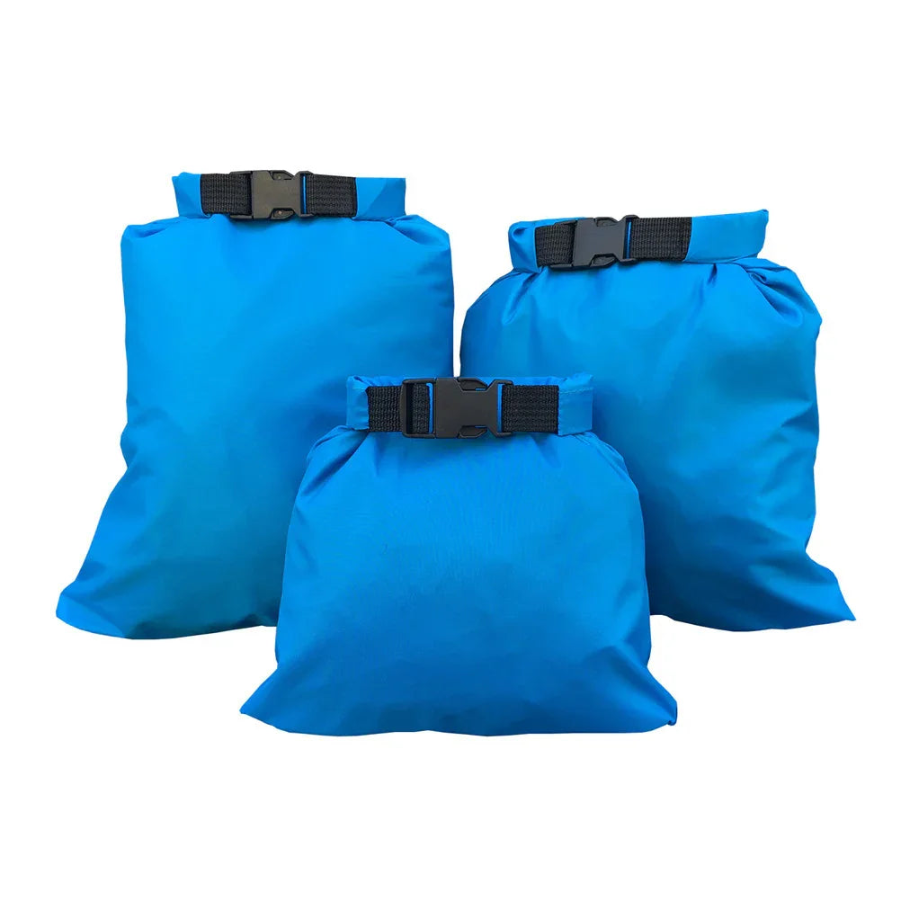 Set of three blue waterproof dry bags with black buckle closures on white background