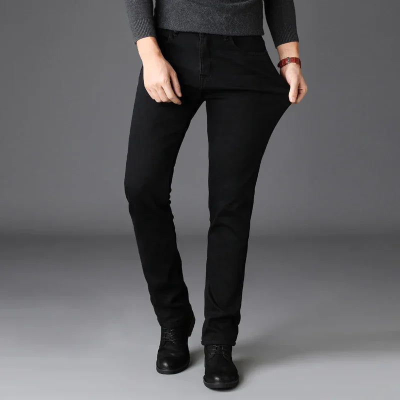 Person wearing black stretchy slim-fit pants and black boots against gray background