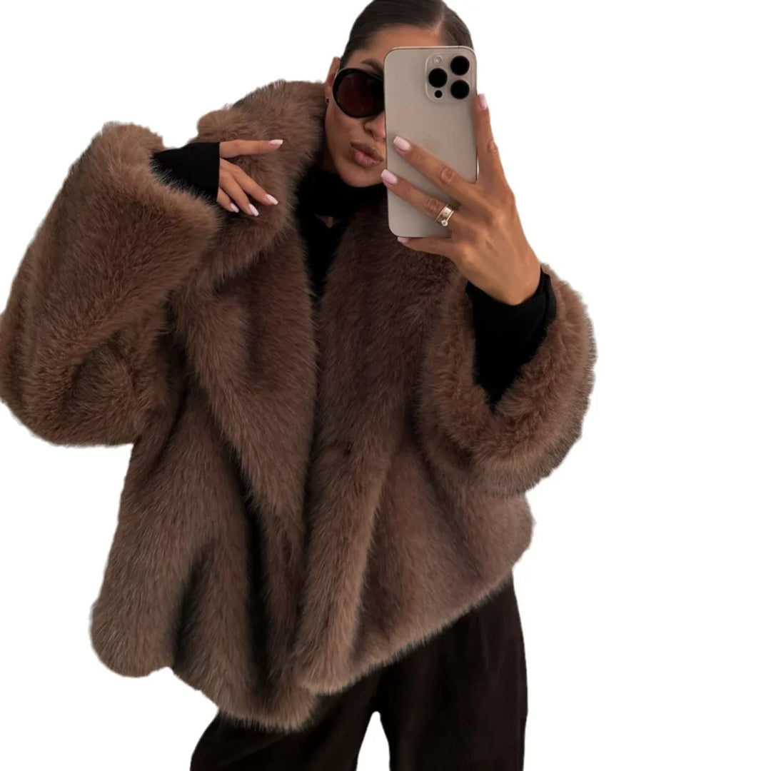 Woman wearing oversized brown faux fur coat and sunglasses taking a selfie with smartphone