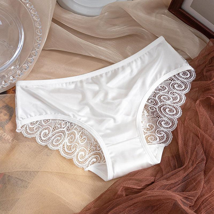 White women's panties with lace detailing on beige and brown fabric background