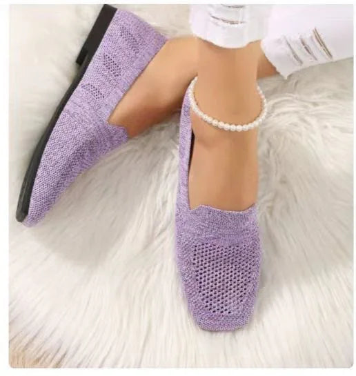 Women's lavender crochet knit loafers on white fur rug with pearl ankle bracelet and white ripped jeans