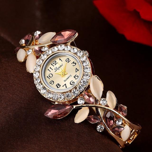 Elegant Lpmqi quartz wristwatch with crystal bezel and floral gemstone bracelet on dark fabric