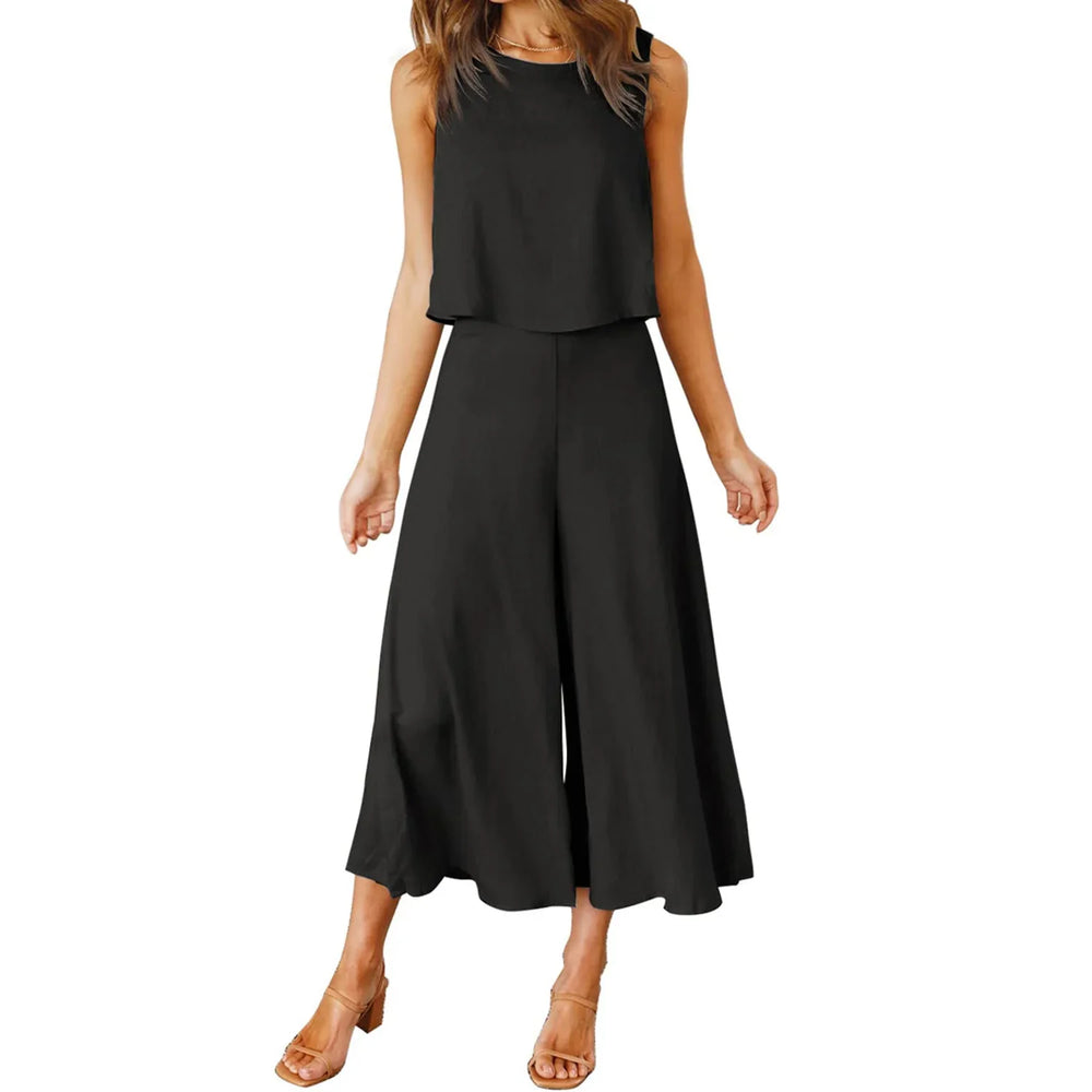Woman wearing sleeveless black crop top and high-waisted wide-leg black pants with tan heeled sandals