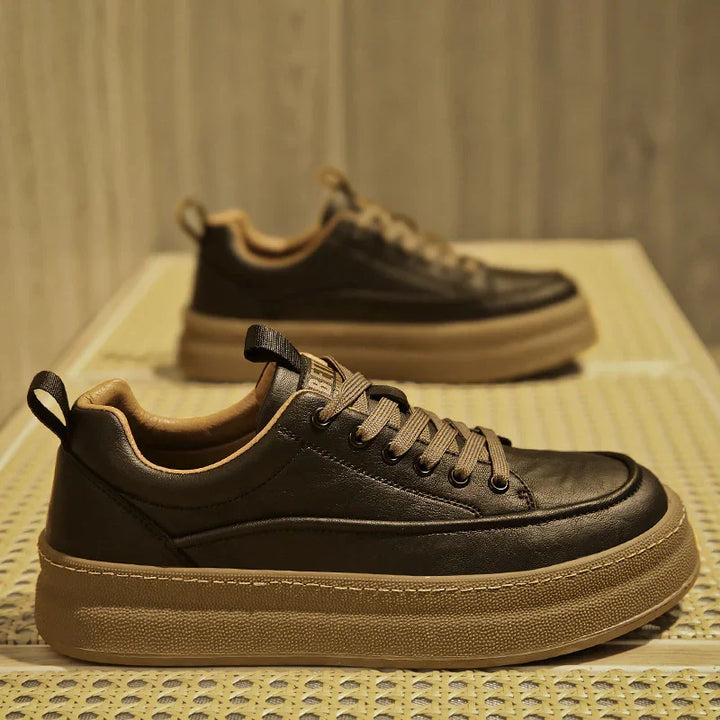 close-up of brown leather platform sneakers with thick beige soles on woven surface