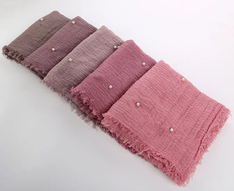 set of six soft textured scarves in shades of pink and mauve with pearl accents and fringed edges