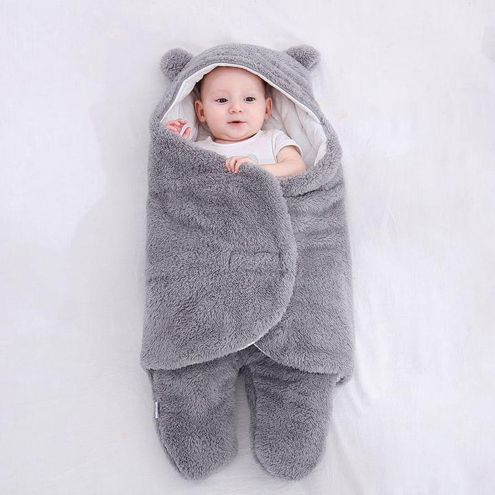 Baby wrapped in soft gray plush swaddle blanket with hood and bear ears on white background