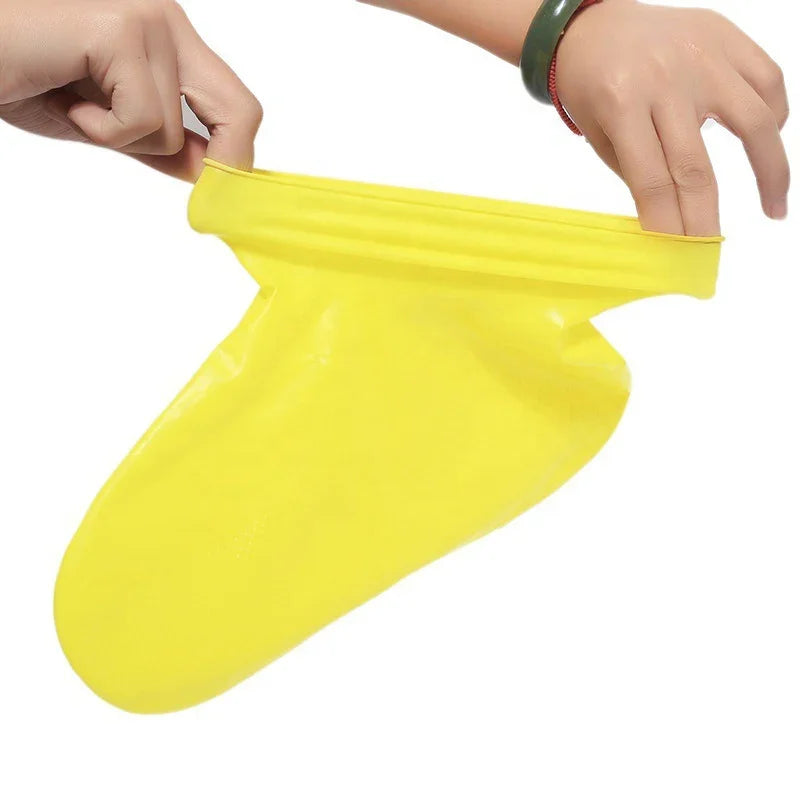 Hands stretching a bright yellow rubber glove on a white background