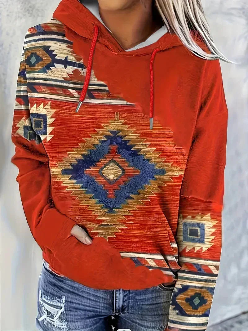 Red hoodie with colorful southwestern geometric patterns worn with ripped blue jeans