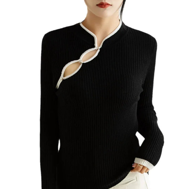 Woman wearing black ribbed knit top with white trim and cutout detail on chest with pearl buttons