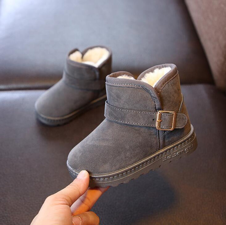 children's gray suede ankle boots with fleece lining and side buckle on dark surface