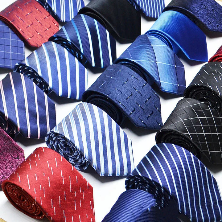 Assorted rolled men's silk ties in various blue, red, and black patterns arranged in rows