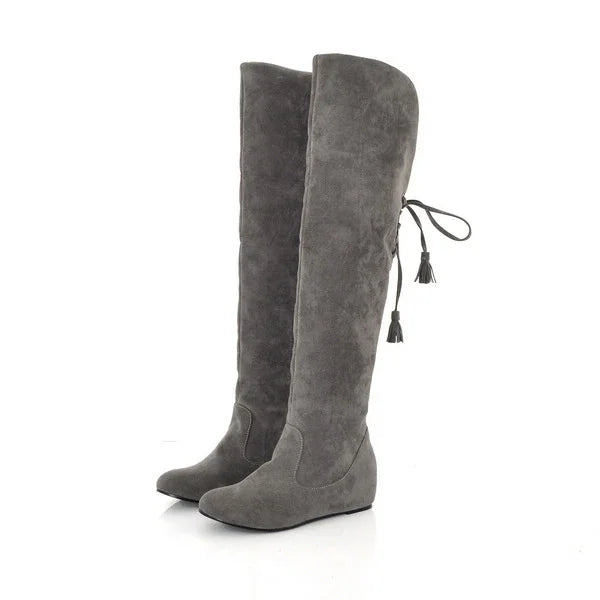 Gray suede over-the-knee flat boots with tassel tie detail on white background