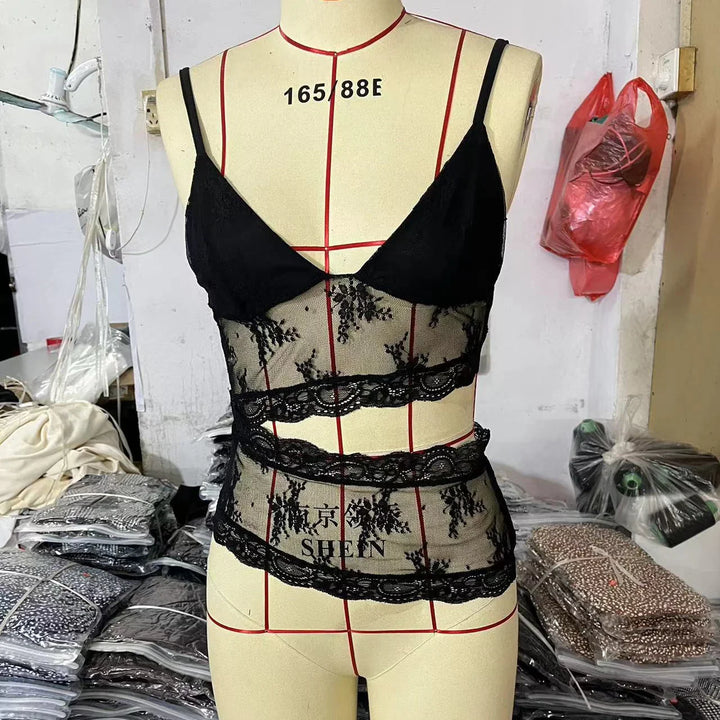 Black lace sheer bralette top displayed on dress form in garment workshop