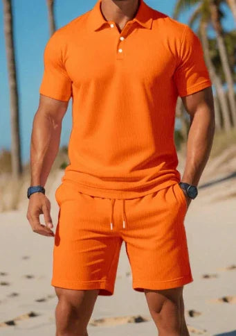 Man wearing bright orange polo shirt and matching shorts on sunny beach with palm trees