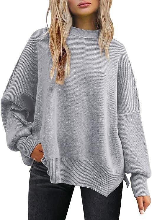 Woman wearing oversized light gray knit sweater with dropped shoulders and ribbed cuffs