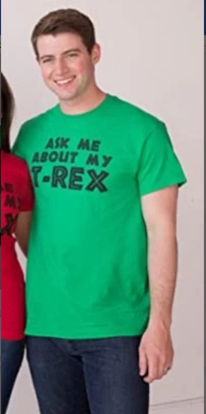 Smiling man wearing a green T-shirt with black text that reads Ask Me About My T-Rex