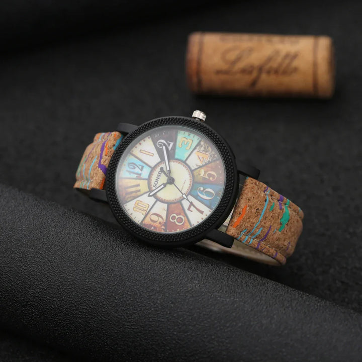 Colorful wristwatch with a round black bezel and multi-colored cork strap on black surface