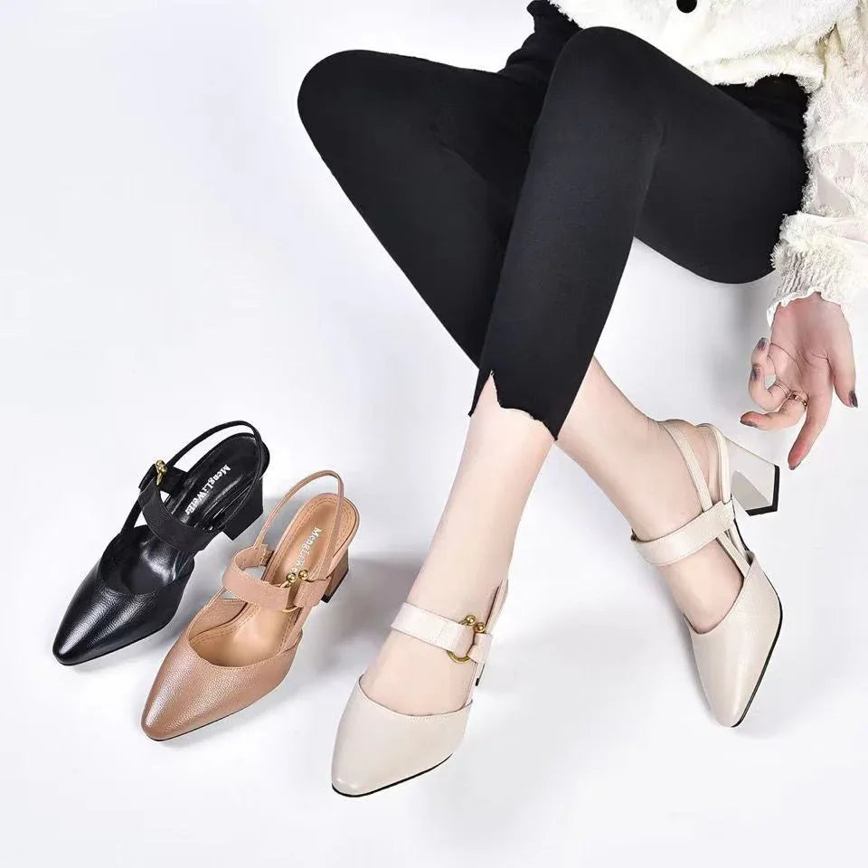 Close-up of woman's legs in black leggings wearing beige block heel shoes with two other pairs in black and brown on white background