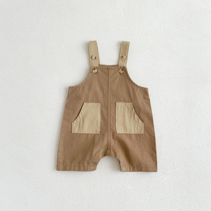 Brown toddler romper with beige adjustable straps and front patch pockets on white background