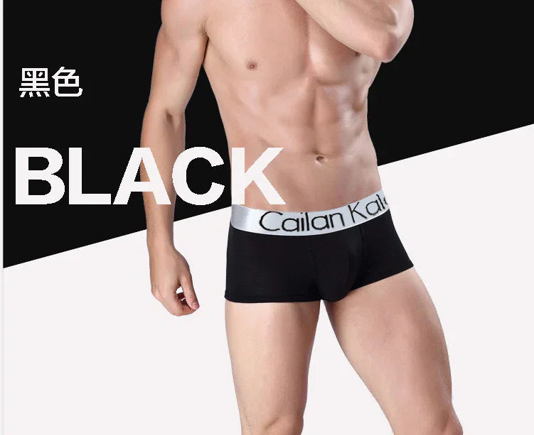 Male model wearing black Cailan Kai boxer briefs with silver waistband on a black and white background
