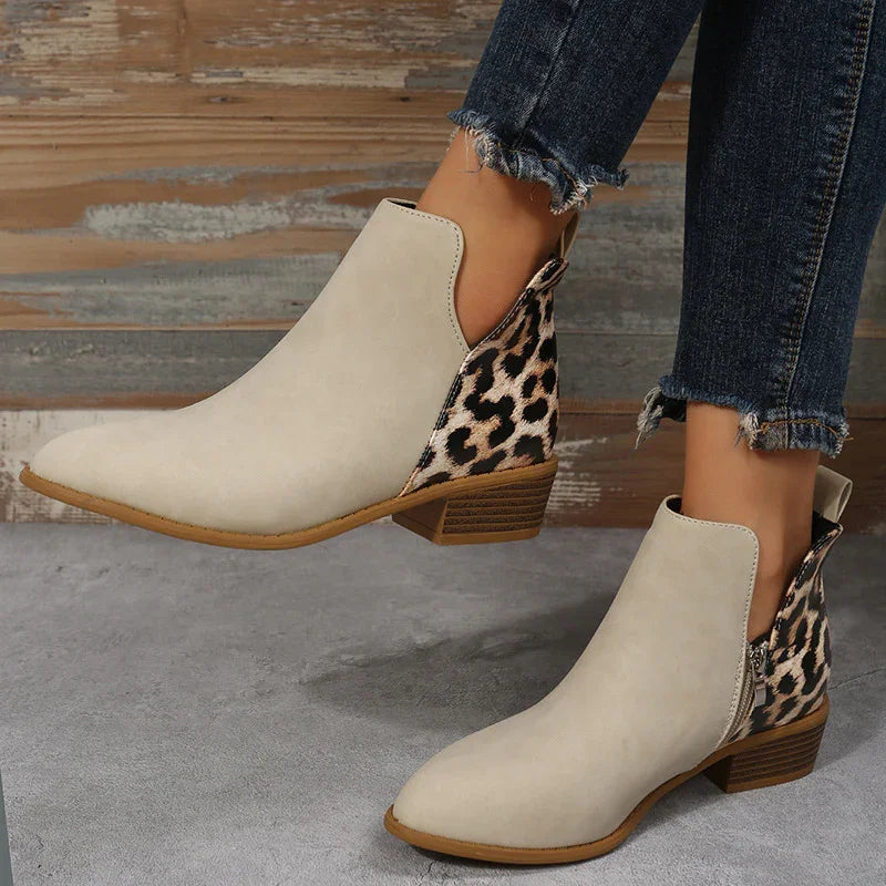 Beige ankle boots with leopard print heel detail worn with frayed hem jeans on wooden floor