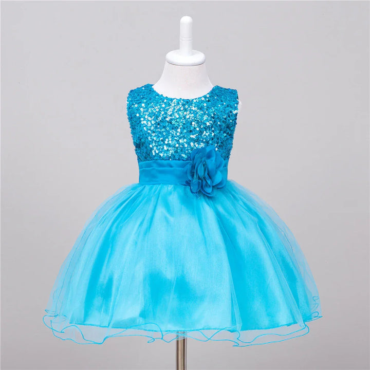Blue sleeveless toddler dress with sequin bodice, satin waistband, flower detail, and tulle skirt on mannequin
