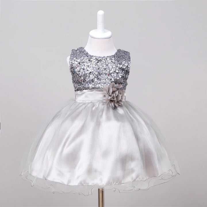 Silver sequin sleeveless baby dress with satin skirt and floral waist embellishment on mannequin