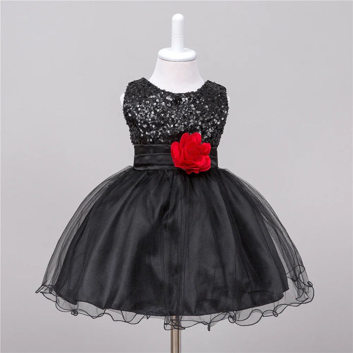 Black toddler dress with sequin bodice, tulle skirt, and red flower accent on waist