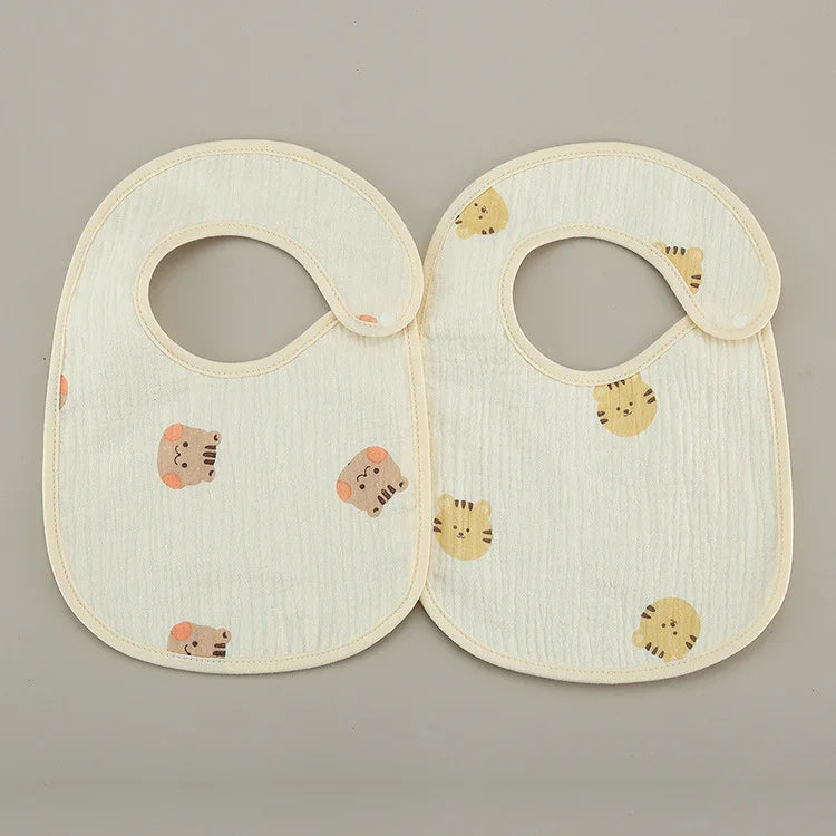 Two soft baby bibs with animal faces pattern on light beige fabric, snap closure on neck
