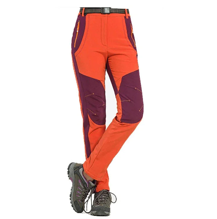 Women's outdoor hiking pants in orange and purple with zippered pockets and black belt