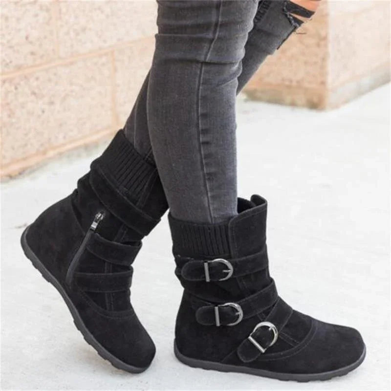 Black suede ankle boots with three buckle straps and knitted cuff worn with gray skinny jeans
