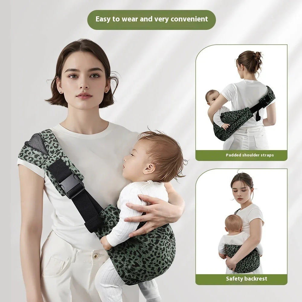 Woman wearing a green leopard print baby sling carrier with padded shoulder straps and safety backrest holding a baby