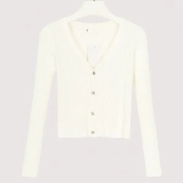 White ribbed long-sleeve cropped cardigan with buttons on hanger against plain background