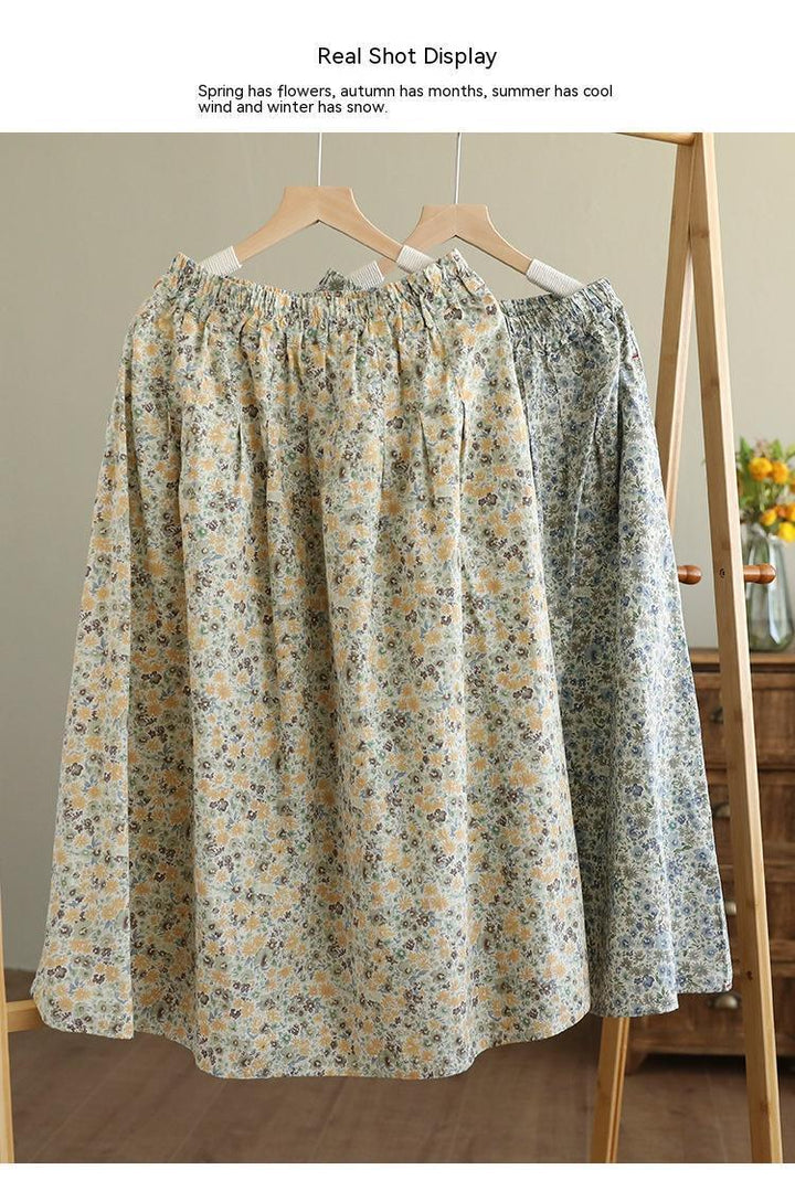 Two floral print skirts with elastic waistbands hanging on wooden hangers on a rack in a cozy room