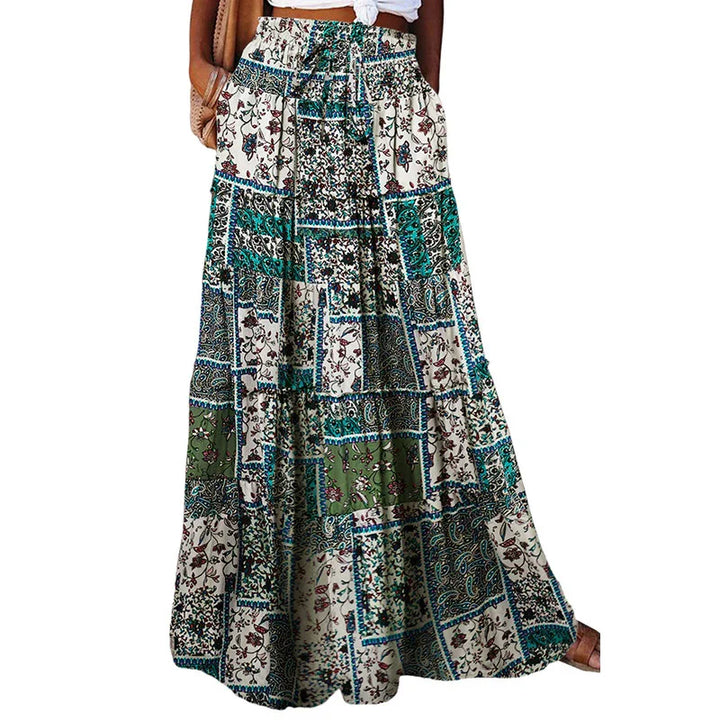 Woman wearing a patchwork floral maxi skirt in green, blue, and cream colors with pockets