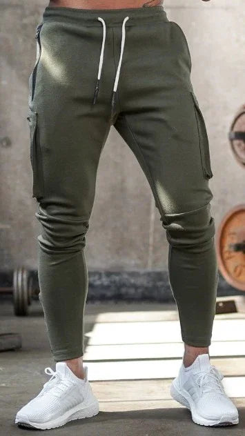 Man wearing slim fit olive green cargo joggers with white drawstring and white athletic shoes