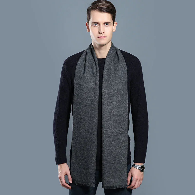 Man wearing a dark gray wool scarf and black sweater against gray background