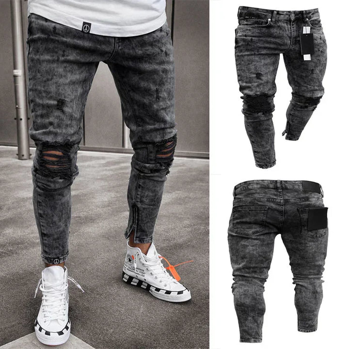 Black distressed slim-fit men's jeans with ripped knees and zip detail, styled with white high-top sneakers