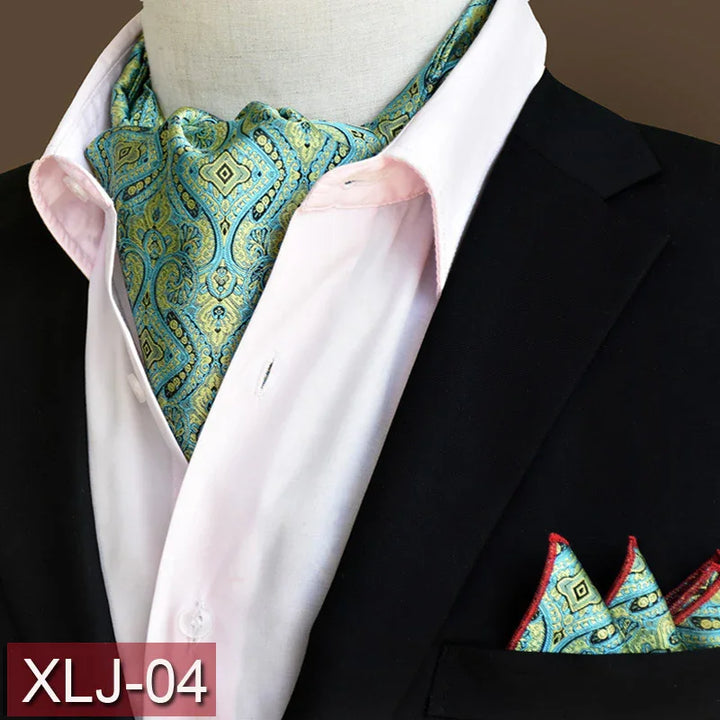 Blue and green paisley ascot tie with matching pocket square on black suit and white shirt