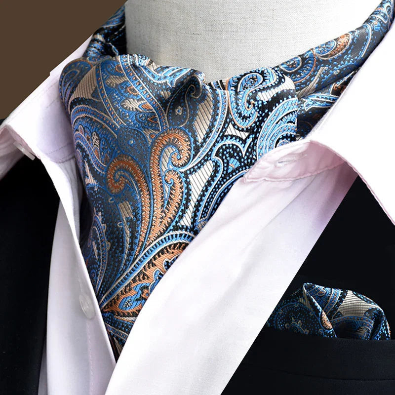 Blue and orange paisley patterned ascot tie paired with white shirt and black jacket lapel