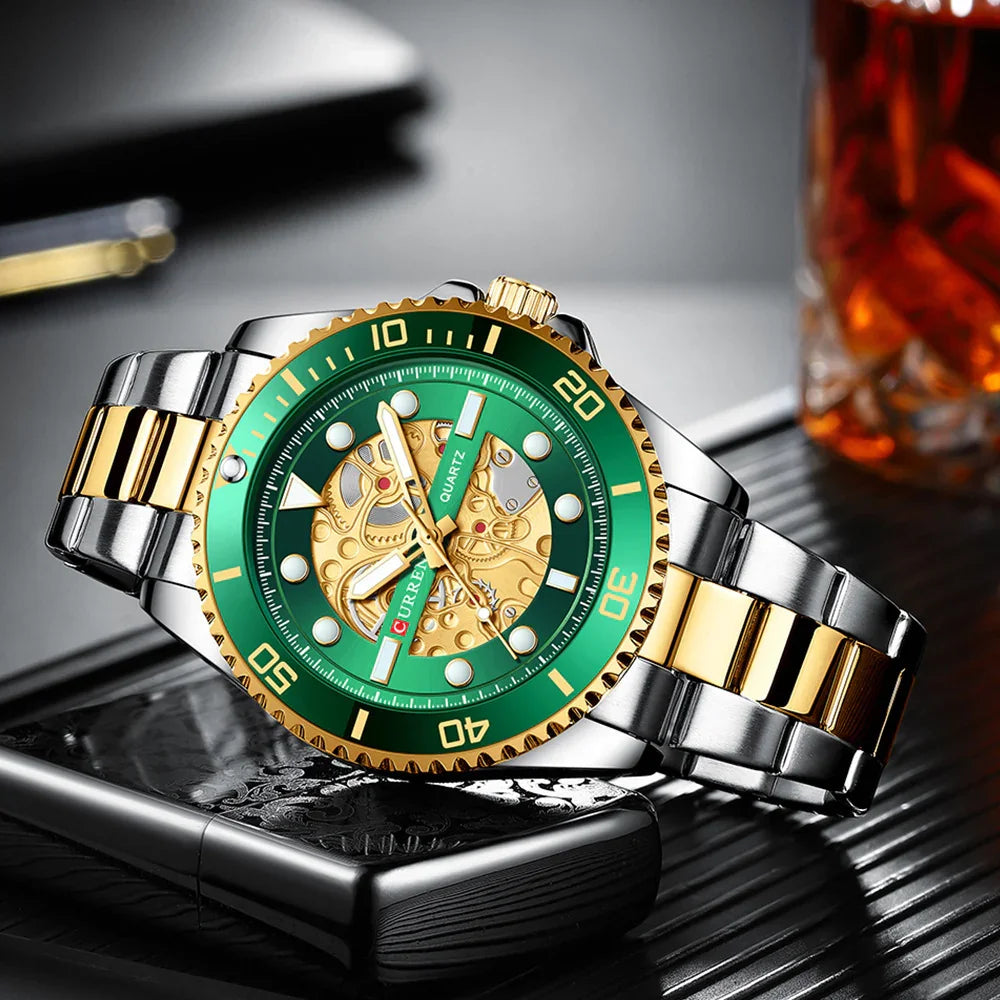 Silver and gold wristwatch with green bezel and intricate gold skeleton dial on a black textured surface