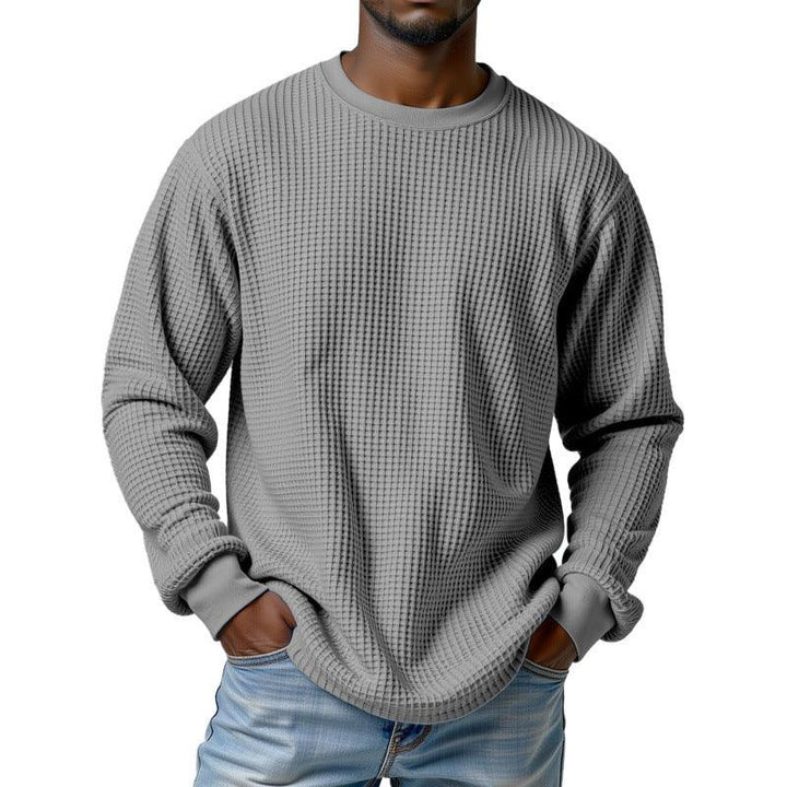 Man wearing gray waffle knit long sleeve shirt with ribbed cuffs and light blue jeans